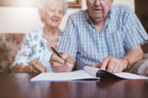 elderly couple signing paperwork