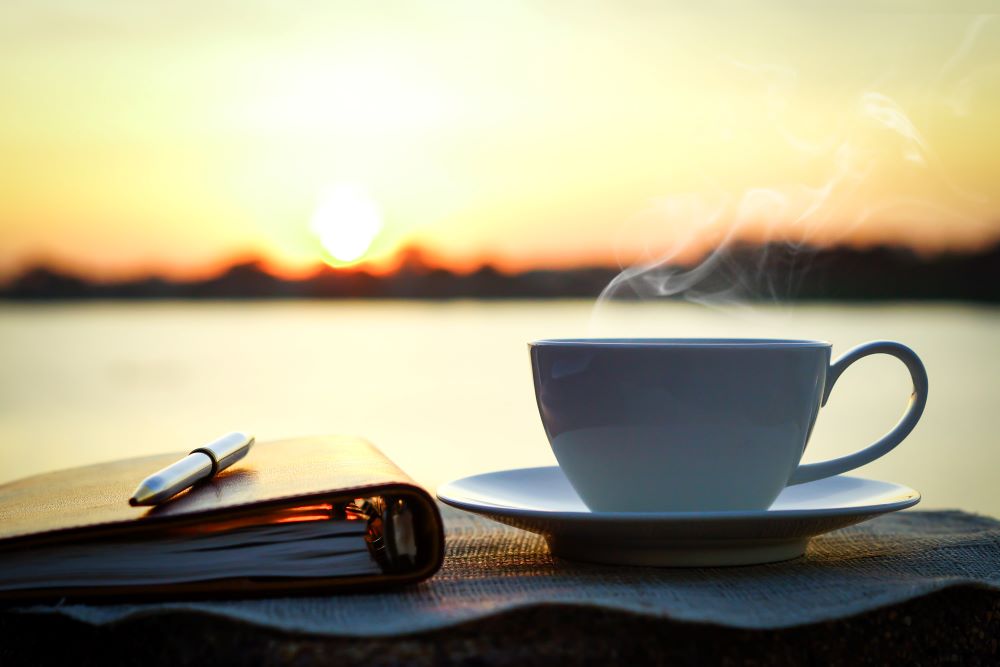 coffee and notebook overlooking sunrise